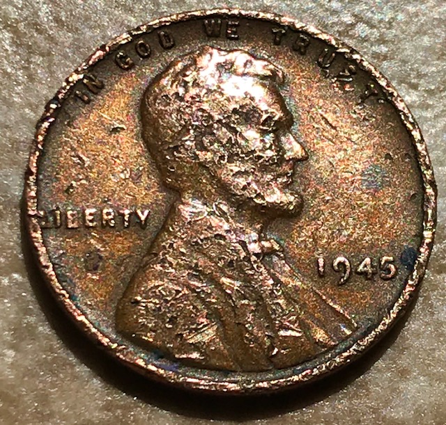 1945 Lincoln cent struck on Netherlands East Indies planchet showing design compressed on foreign planchet beside normal 1945 wheat penny for comparison
